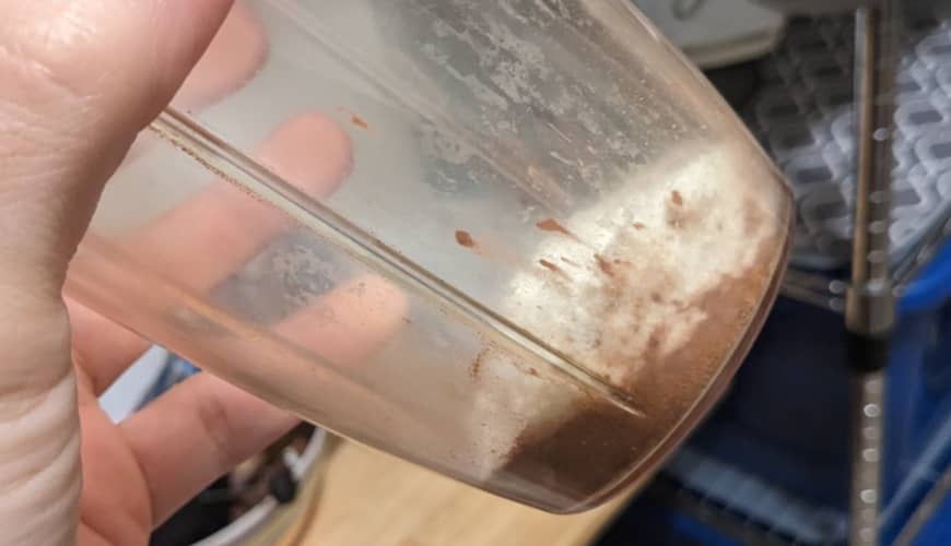 Cacao, leche y canela, todo en polvo, en el envase de la batidora.